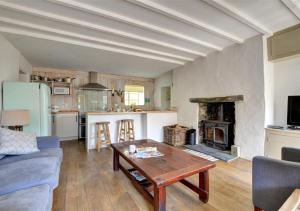 uma sala de estar com uma mesa e uma lareira em Stable Cottage em Tywyn