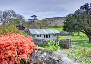 uma casa branca no meio de um campo em Stable Cottage em Tywyn