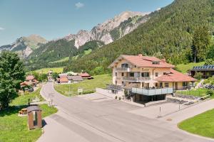 a house on a street with a mountain in the background at Stockingers Guest House in Klösterle