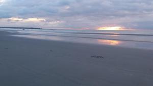 ブローニュ・シュル・メールにあるLe Vivierの遠くに夕日が沈むビーチ
