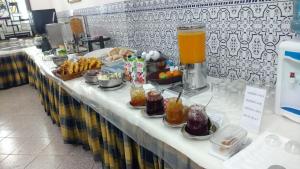 a table topped with plates of food and drinks at Hotel Peninsular- Porto in Porto