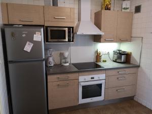 a kitchen with a stainless steel refrigerator and microwave at La maison Bleue in Céreste