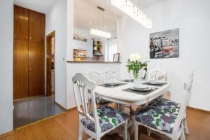 a white dining room with a white table and chairs at Zeleni kuk in Solin