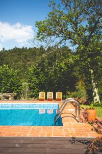 a swimming pool with a slide next to two chairs at Out of Town in Castelo de Paiva