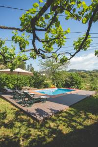 a swimming pool with two lounge chairs and an umbrella at Out of Town in Castelo de Paiva