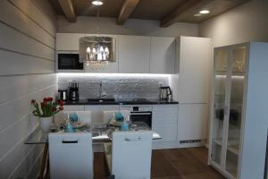 uma cozinha com armários brancos e uma bancada em Naava Chalet 304 Pandatupa em Ahtari