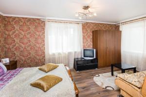 チュメニにあるApartment on 50 let Oktyabrya 51 TyumGNGUのベッドルーム(ベッド1台、テレビ、ソファ付)