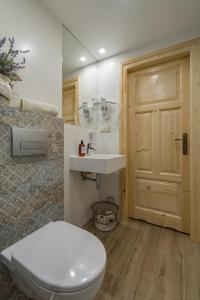 a bathroom with a white toilet and a sink at Domek Szałas pod Dębem in Ząb +13 photos