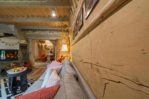 a living room with a couch and a wooden wall at Domek Szałas pod Dębem in Ząb