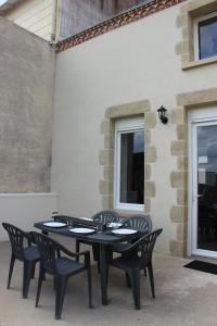 einen schwarzen Tisch und Stühle auf einer Terrasse in der Unterkunft A chacun son nid in Les Épesses