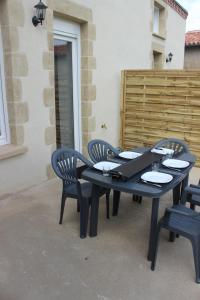 une table et des chaises noires assises sur une terrasse dans l'établissement A chacun son nid, aux Épesses