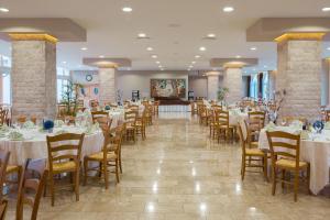 a banquet hall with white tables and chairs at Medjugorje Hotel & Spa in Međugorje