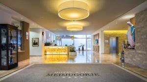 a lobby of a hotel and spa with a large chandelier at Medjugorje Hotel & Spa in Međugorje