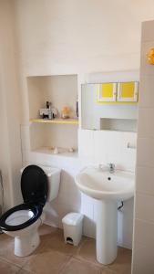 a bathroom with a black toilet and a sink at L'Orca di San Gavinu in Figari