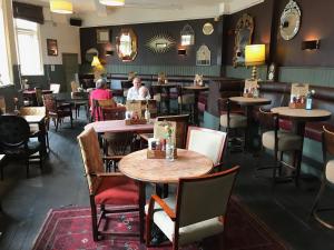 a restaurant with tables and chairs and people sitting at them at The Long Room Hotel and Bar in London +19 photos