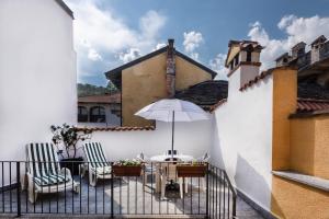 Casa Beatrice في بيلا: فناء مع طاولة وكراسي ومظلة