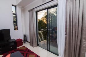 a living room with a large window with a view at Luxury 2 Bedroom Lifestyle Apartment in Golf Estate in Roodepoort