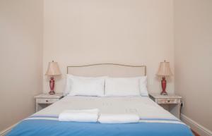 1 dormitorio con 1 cama con toallas en Harbour Views, en Kalk Bay