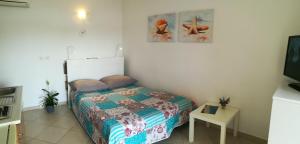 1 dormitorio pequeño con 1 cama y TV en Apartments Oaza Regi en Medulin