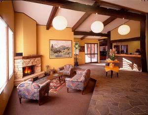 a living room with chairs and a fireplace at Hakuba Alpine Hotel in Hakuba