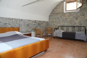 una camera con due letti e sedie e una finestra di Cozy villa with garden a Toirano
