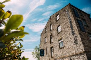 a tall brick building against a blue sky at 1823 Spinning Block in Clitheroe