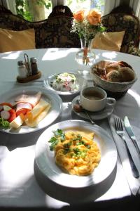 una mesa con platos de comida y pan. en Pensjonat Irena, en Sopot