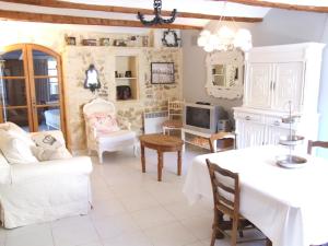 a living room with white furniture and a table at La Voûte de Lapparan in Saint-Drézéry