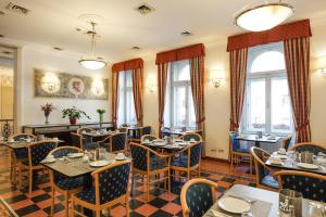 a restaurant with tables and chairs and windows at Hotel Tivoli Prague in Prague