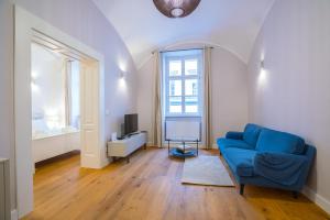 Deluxe Apartment Talia في زغرب: غرفة معيشة مع أريكة زرقاء وتلفزيون