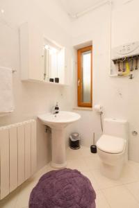 a white bathroom with a sink and a toilet at Apartment Atlantis in Pula