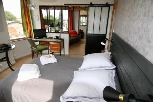 2 Betten in einem Zimmer mit einem Schreibtisch und einem Schreibtisch in der Unterkunft bibou's room Paris in Les Lilas