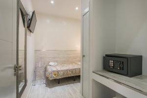 a small bathroom with a bed and a tv at Hostal Met Madrid in Madrid