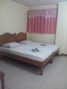 Cama en habitación con ventana rosa en Bee Hub Pension, en Surigao