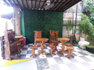 a group of wooden chairs and tables on a checkered floor at Bee Hub Pension in Surigao