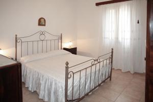 - une chambre avec un grand lit et un couvre-lit blanc dans l'établissement Appartamento Cherubina, à San Vito Lo Capo