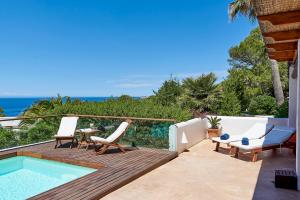 een patio met een zwembad, stoelen en een tafel bij Can Mares in Cala Tarida