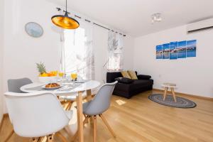 a dining room and living room with a white table and chairs at Cvit Jadrana in Split +33 photos