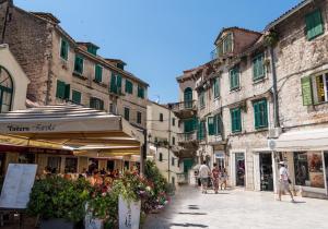 a group of people walking down a street with buildings at Cvit Jadrana in Split