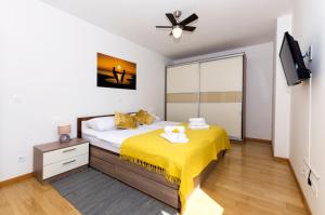 a bedroom with a bed with a yellow blanket on it at Cvit Jadrana in Split