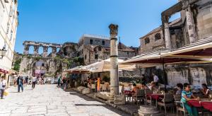 a street with tables and umbrellas in front of a building at Cvit Jadrana in Split