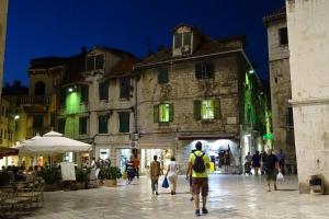 a group of people walking down a street at night at Cvit Jadrana in Split
