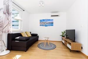a living room with a black couch and a tv at Cvit Jadrana in Split