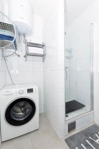 a washer and dryer in a white tiled bathroom at Cvit Jadrana in Split