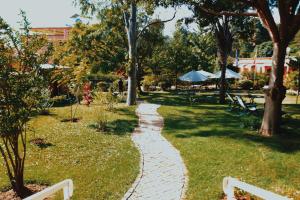 a cobblestone path through a park with trees at Hôtel Mahavelo 2 étoiles in Antananarivo
