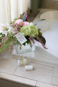un ramo de flores sentado en el lavabo del baño en Rogue Regency Inn & Suites, en Medford