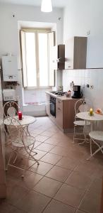 ローマにあるMyomax Guesthouseのキッチン(テーブル、椅子付)、キッチン(コンロ付)
