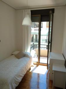 a bedroom with a bed and a desk and a window at KM0 CENTRO CIUDAD in Valencia