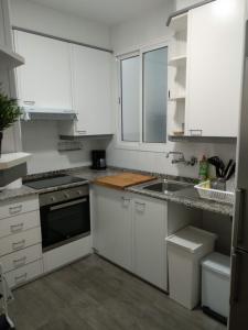 uma cozinha com armários brancos e um lavatório em KM0 CENTRO CIUDAD em Valência