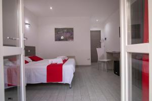 Schlafzimmer mit einem Bett mit einer roten und weißen Decke in der Unterkunft La Maison de Monet in Brindisi